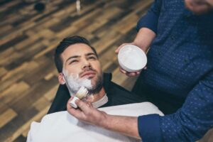 barber-applying-foam-before-shaving-of-customer-in-FGU8KN4